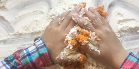a child's hands preparing sweet potato gnocchi